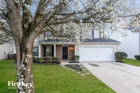 A house with a tree in front of it.