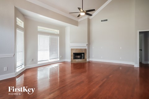 an empty living room with wood floors and a fireplace