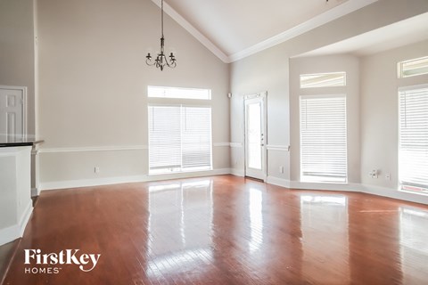 an empty living room with wood floors and windows