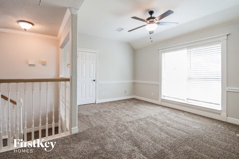 a nursery with a crib and a ceiling fan