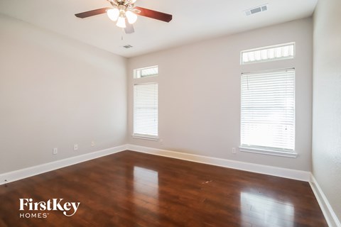 a living room with wood floors and a ceiling fan