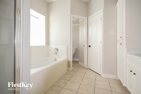 a bathroom with a tub and a door to a closet