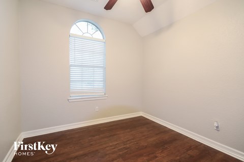 the living room of a home with wood floors and a window