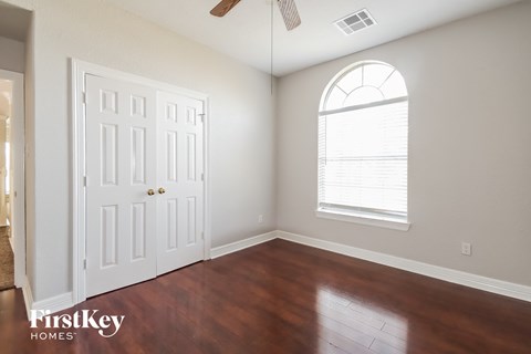 an empty living room with wood floors and a window