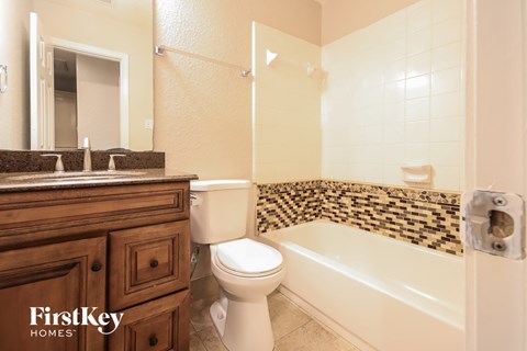 a bathroom with a toilet and a tub and a sink