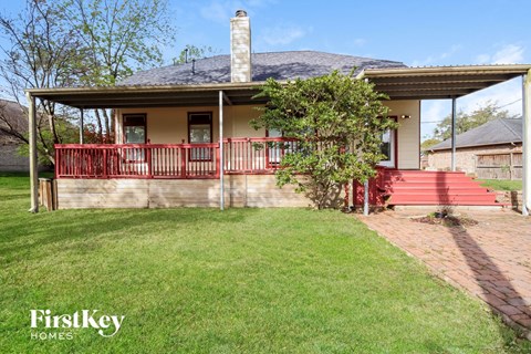 a house with a red porch and a green lawn