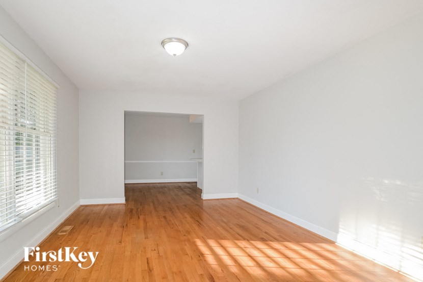 a renovated living room with wood floors and white walls