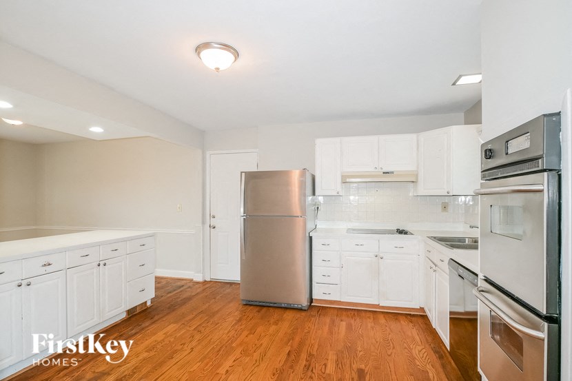 a renovated kitchen with white cabinets and stainless steel appliances