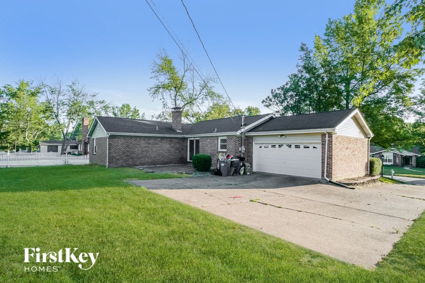 a brick home with a white garage door and a lawn