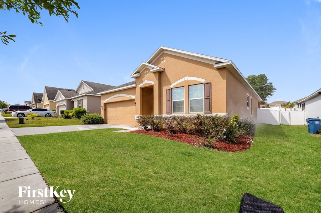 a home with a lawn and a sidewalk in front of it