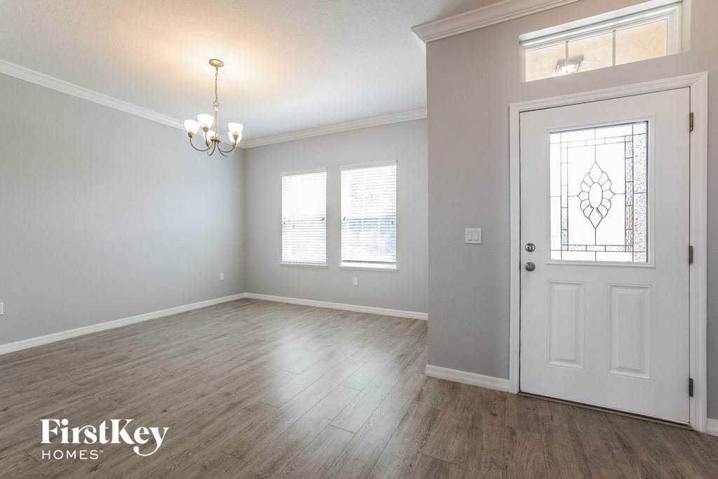 the living room and dining room of a house with a white door
