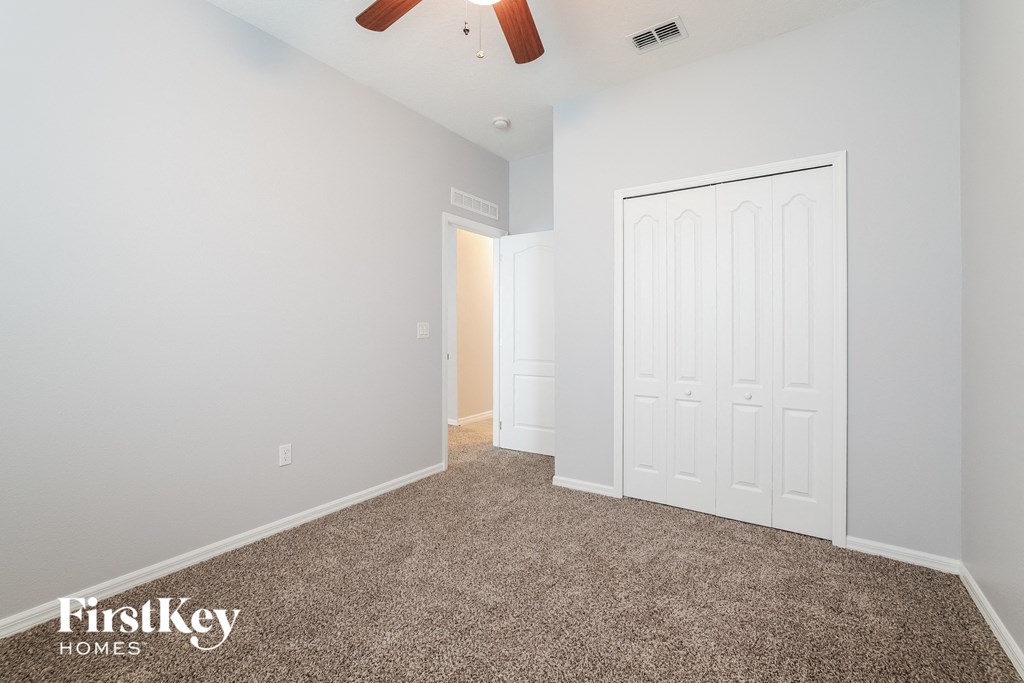 a bedroom with a white door and a carpeted floor