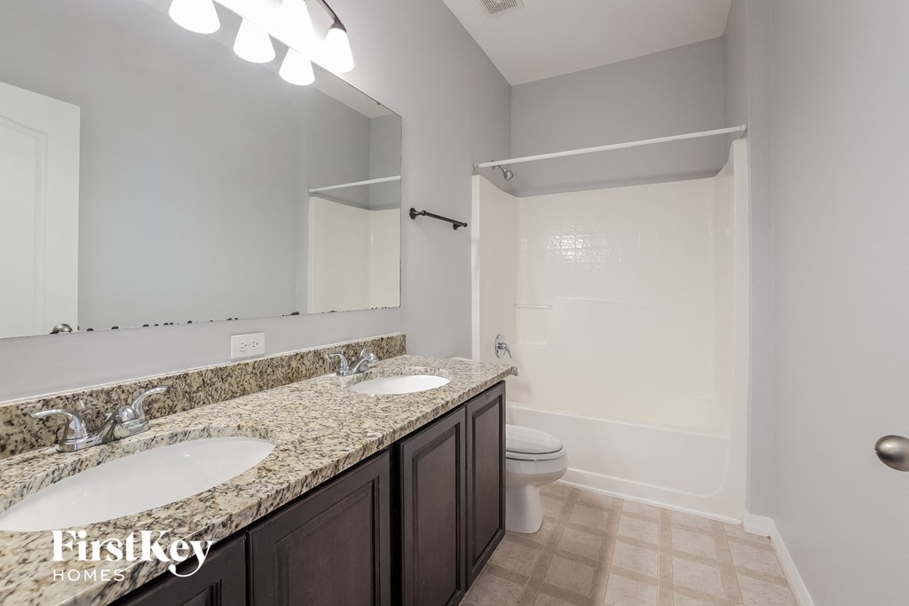 a bathroom with two sinks and a shower and a toilet