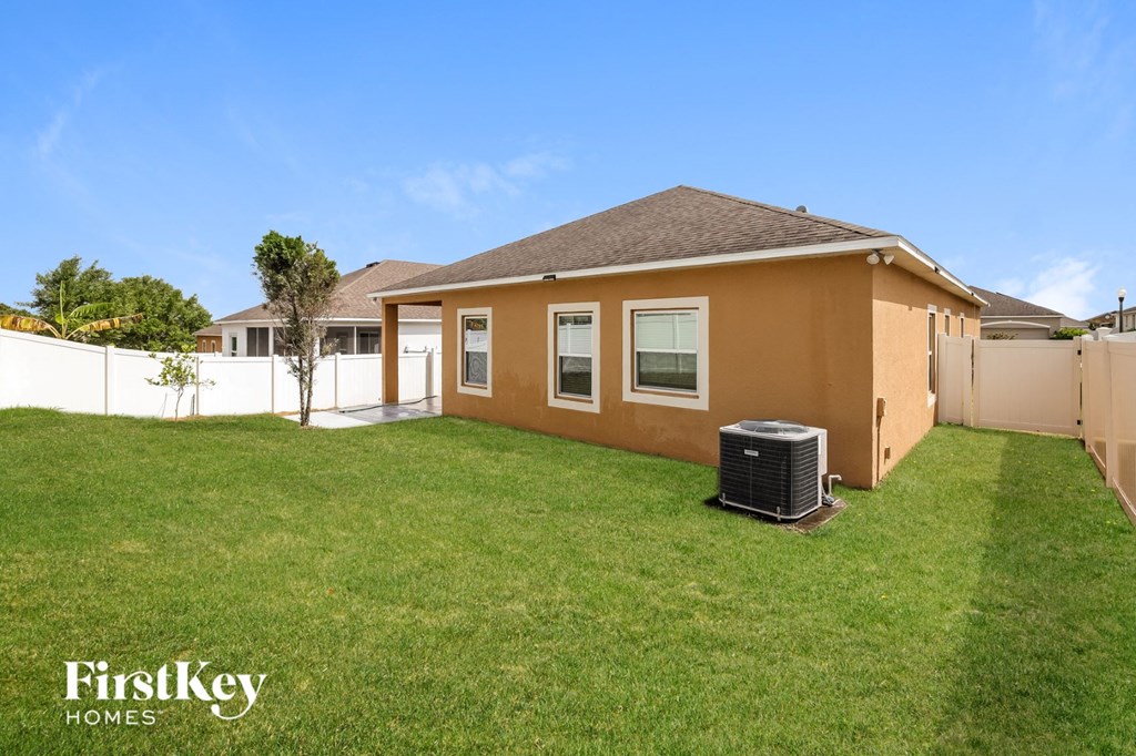 a backyard with a house and a heater on the grass