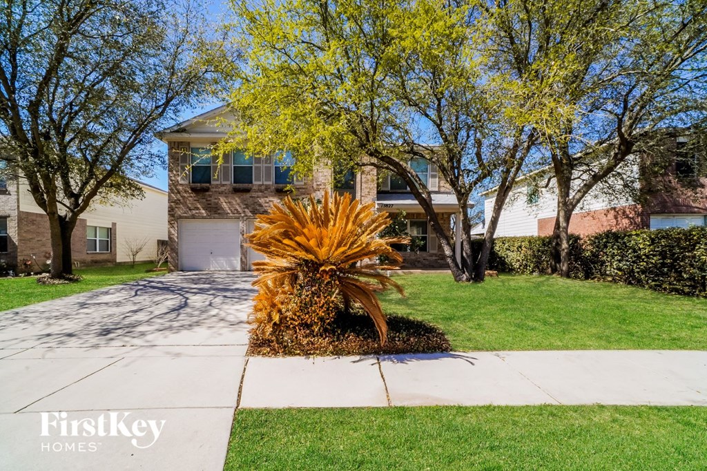 a house with a lawn and trees in front of it