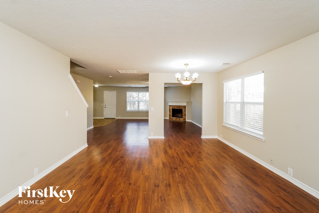 the living room and dining room with hardwood flooring and a fireplace
