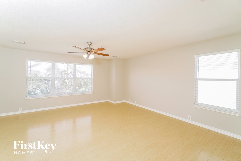 a living room with a ceiling fan and a wood floor