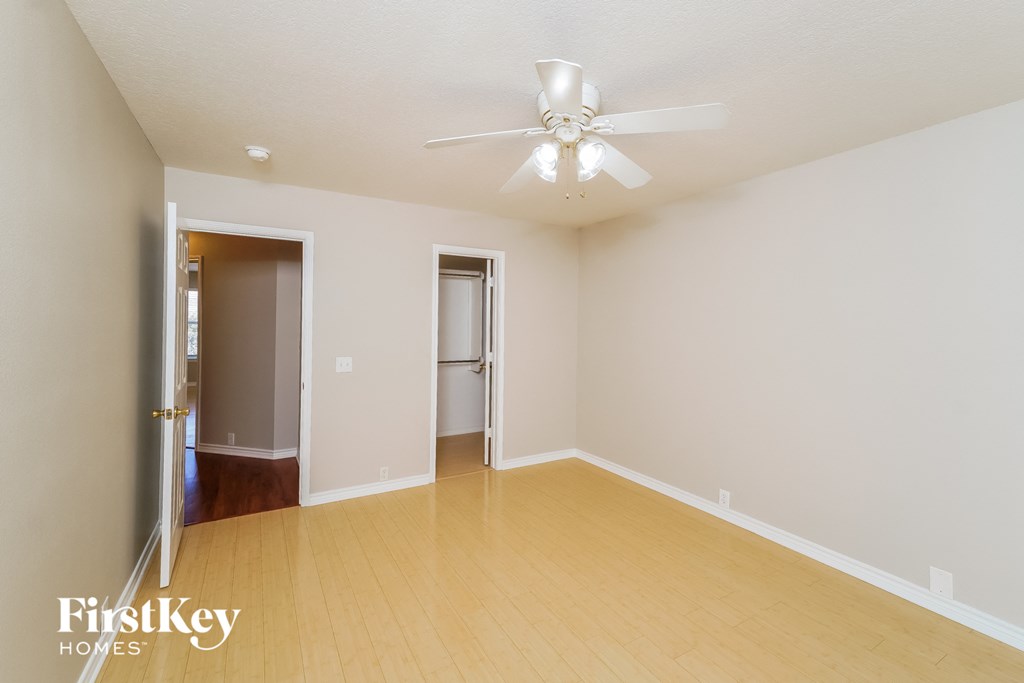 a spacious living room with wood flooring and a ceiling fan