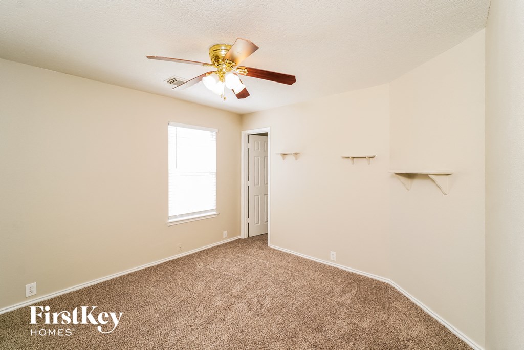 a bedroom with carpet and a ceiling fan