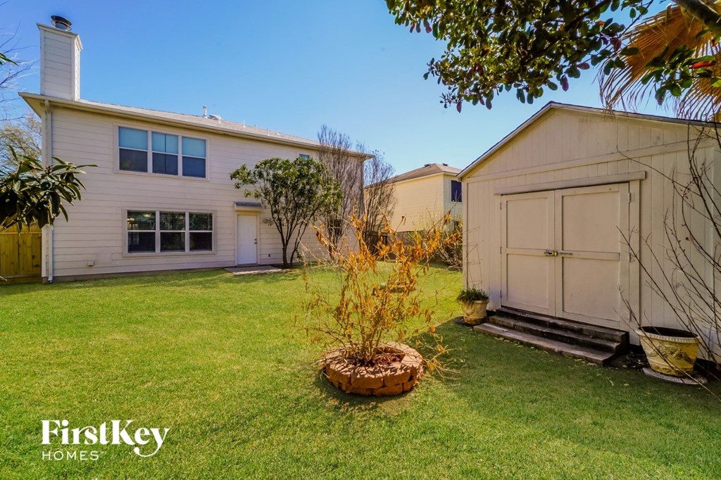 a backyard with a house and a garage
