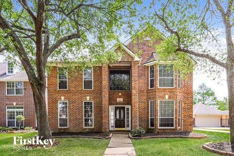 a brick house with trees in front of it