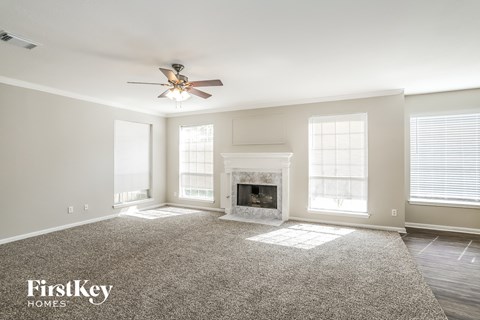 a living room with a fireplace and a ceiling fan