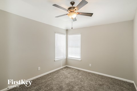 a bedroom with a ceiling fan and a window