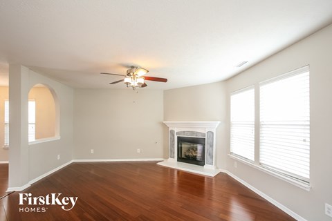 a living room with a fireplace and a ceiling fan