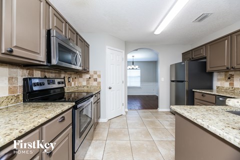 A kitchen with brown cabinets and a tiled backsplash.