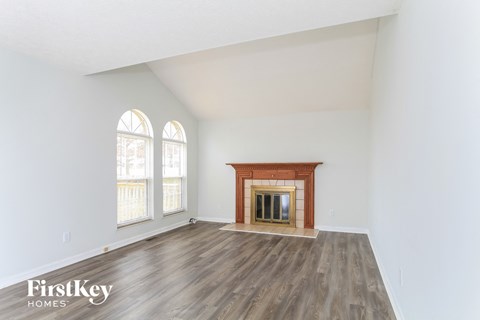 the living room with wood flooring and a fireplace