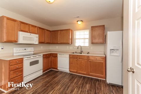 A kitchen with wooden cabinets and a white fridge.
