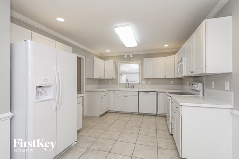 a white kitchen with white cabinets and white appliances