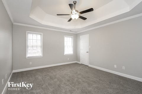 a living room with carpet and a ceiling fan