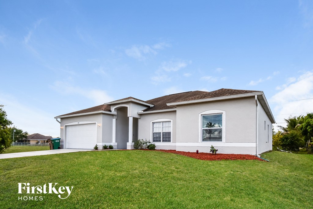 a white house with a lawn in front of it