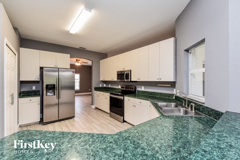 a kitchen with green granite counter tops and stainless steel appliances