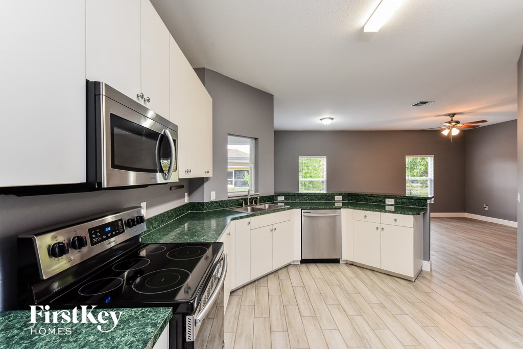 a kitchen with green counter tops and stainless steel appliances