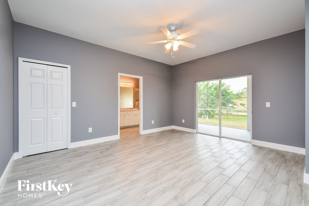 an empty living room with grey walls and a white wooden floor