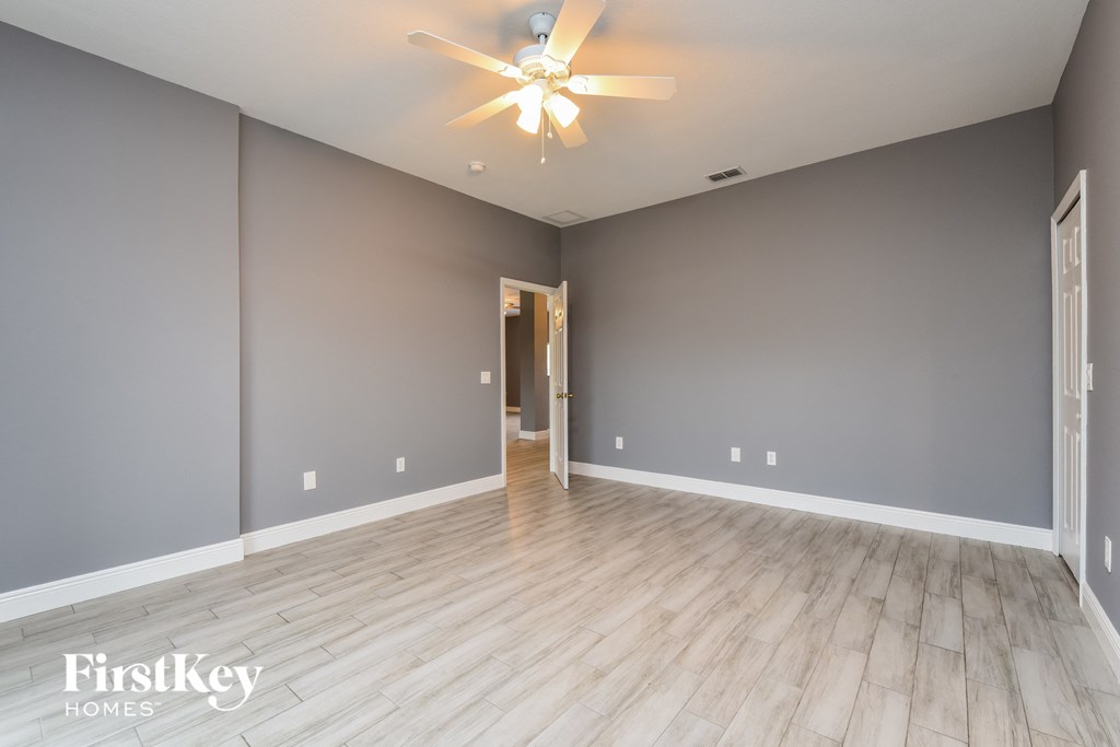 the living room of an empty house and a ceiling fan