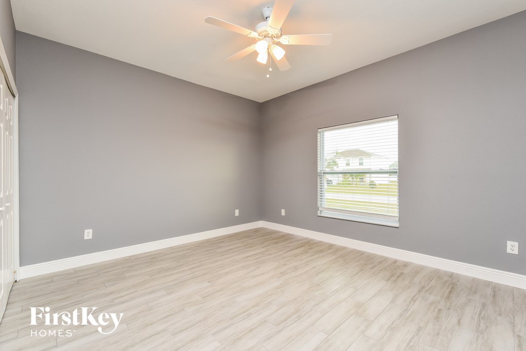 the living room with wood flooring and a ceiling fan