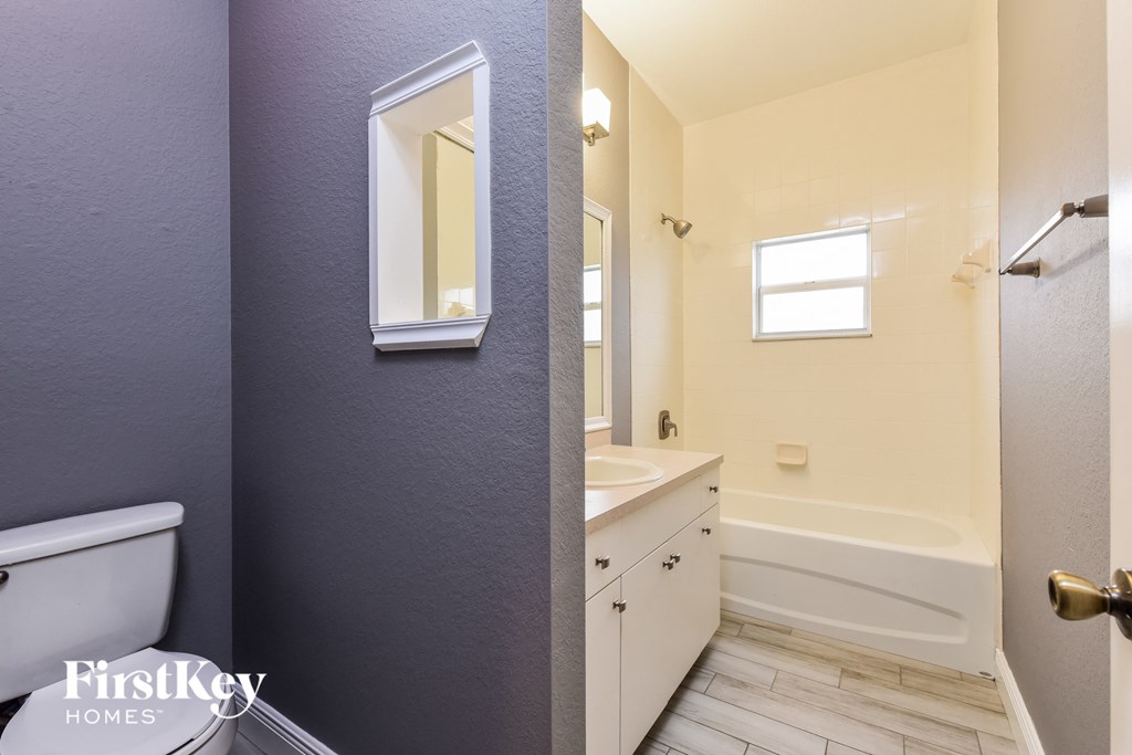 a bathroom with a toilet sink and tub and a mirror