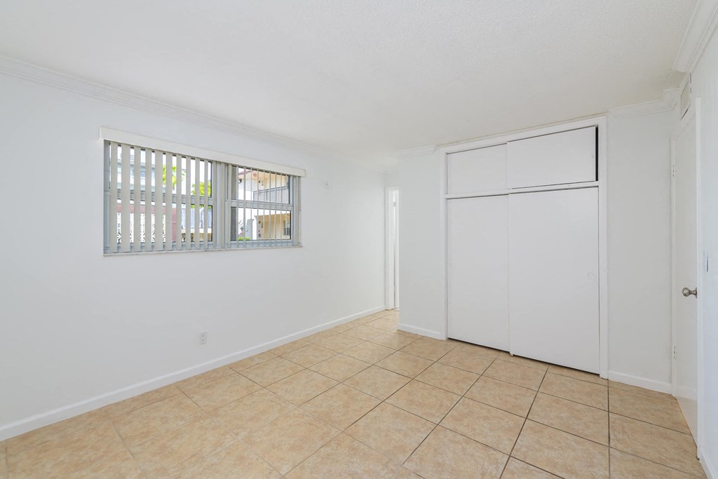a room with a door and a window and a tiled floor