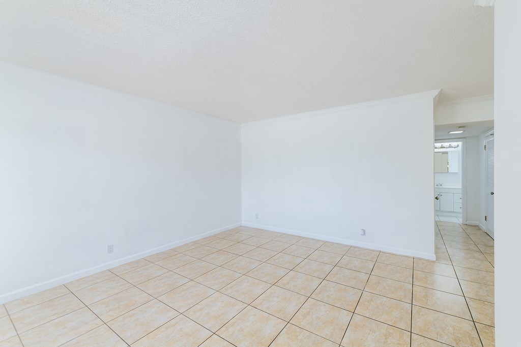 the living room and dining room of an empty house with white walls and tile floor