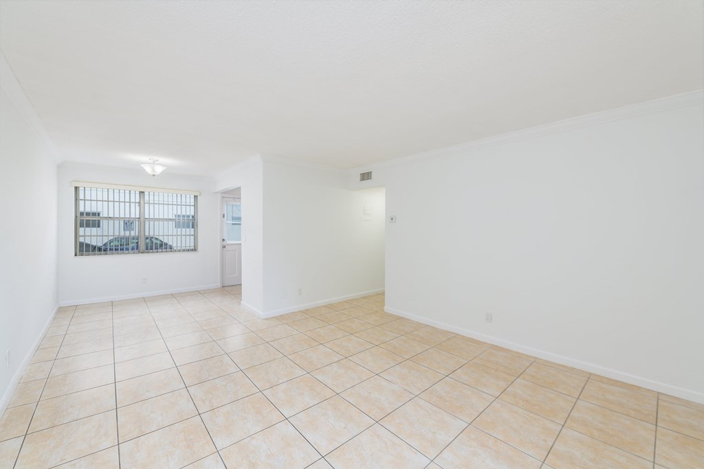 the living room and dining room of an empty home with tile flooring