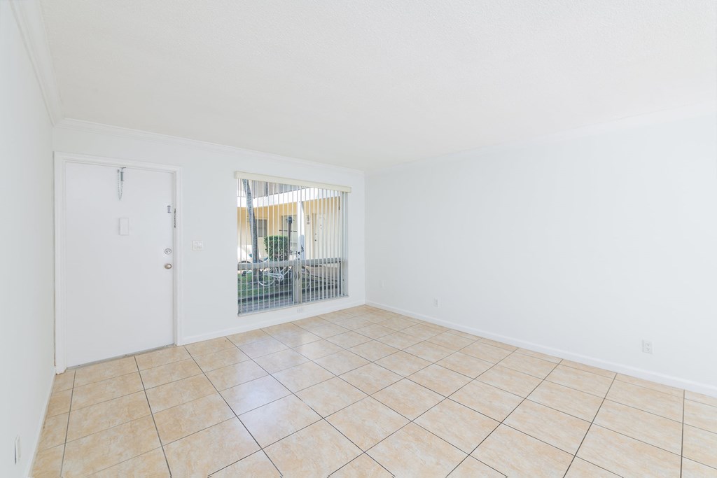 the living room and dining room of an empty home with tile flooring