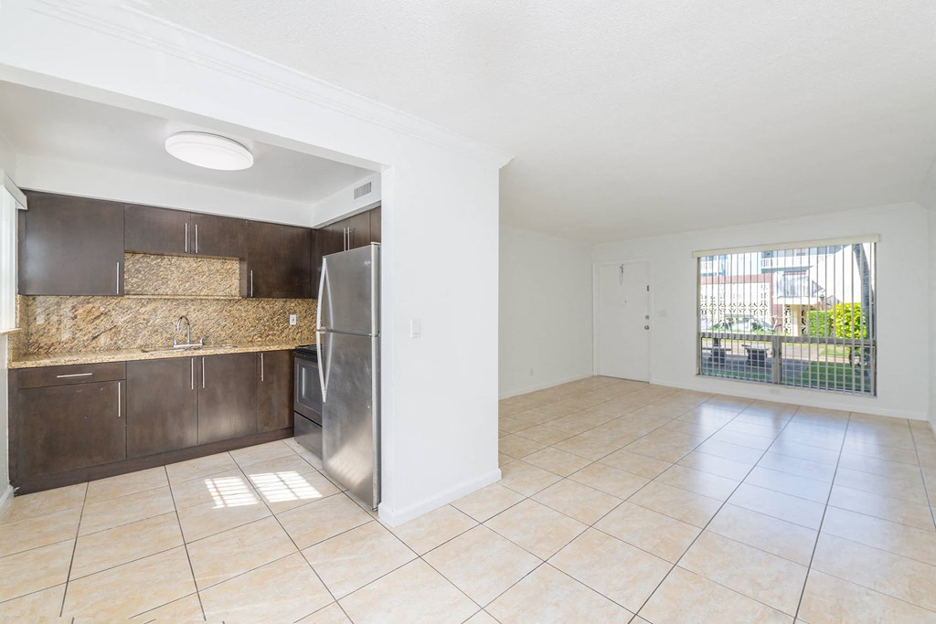 a kitchen with a stainless steel refrigerator and a window