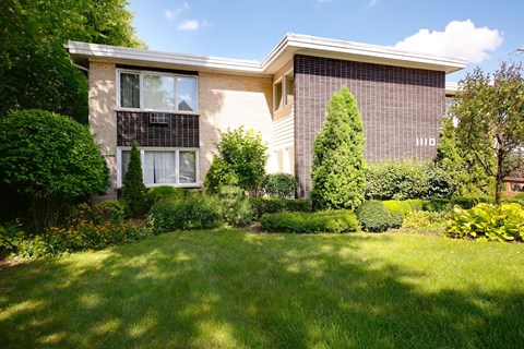 A house with a well-kept lawn in front.