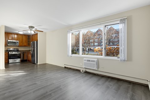 A spacious kitchen with wooden cabinets and a refrigerator.