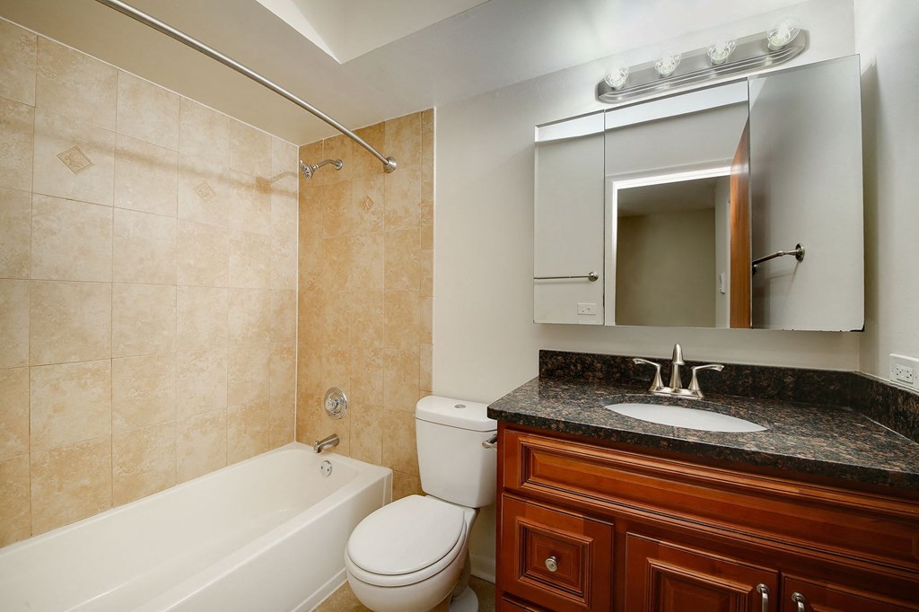 a bathroom with a toilet sink and tub and a mirror