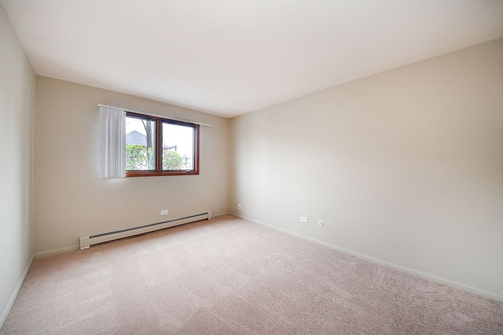 a spacious living room with carpet and a window