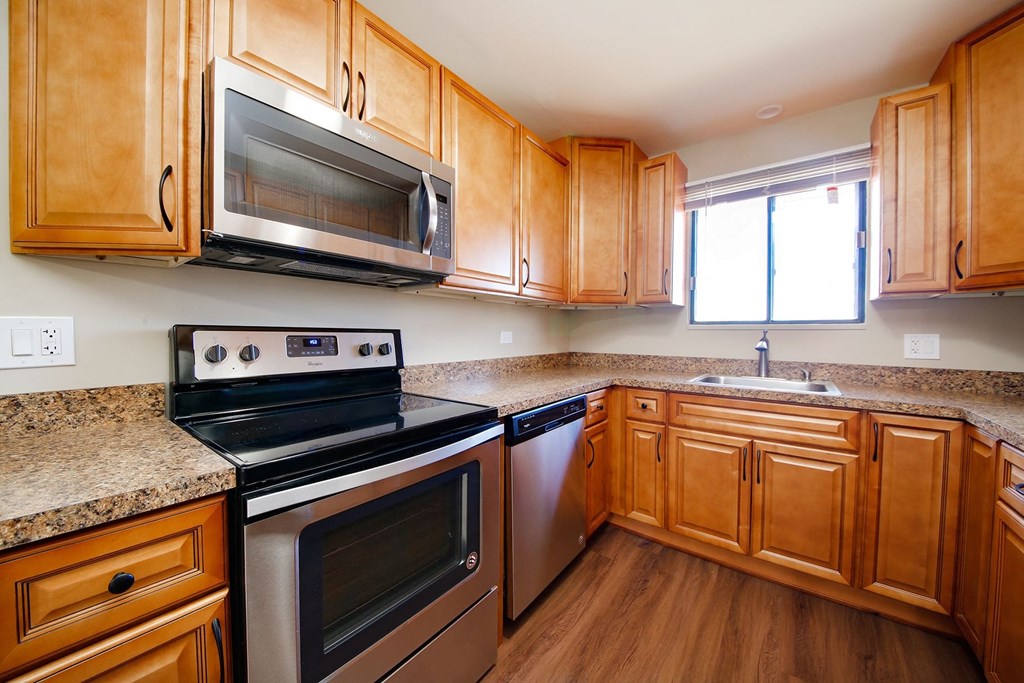 a kitchen with stainless steel appliances and wooden cabinets